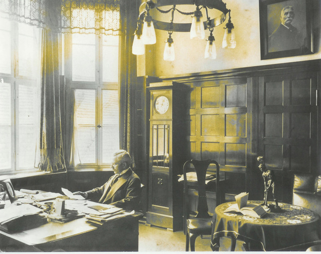 Das Bild zeigt ein Büro von früher mit einem Mann.