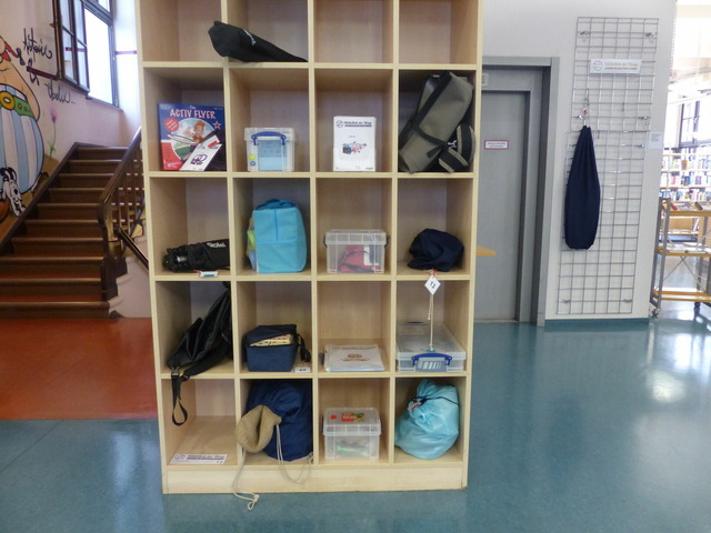 Das Bild zeigt ein Regal mit großen Dingen