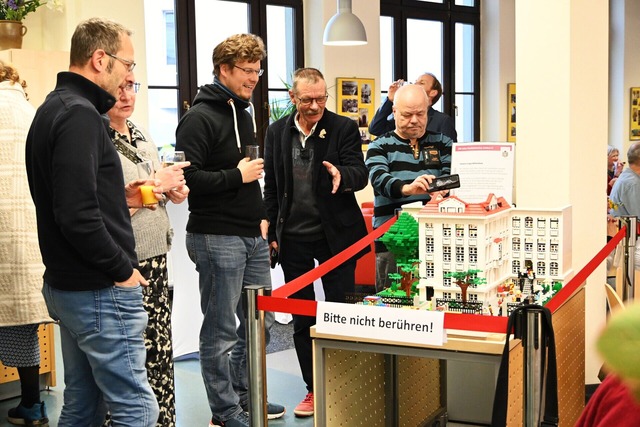 Vertreter vom Bauteam und Besucher bestaunen das Lego Haus, c Michael Roge